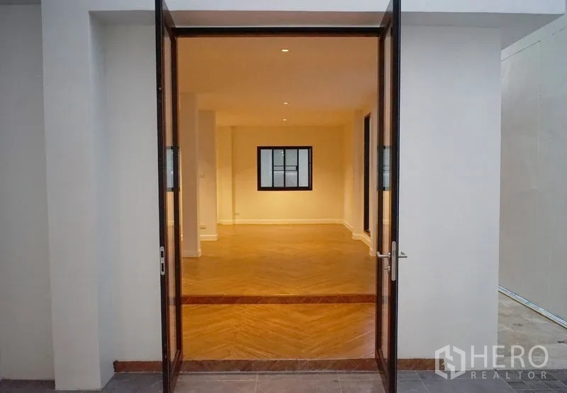 带办公室的家 出租或出售在Watthana, Bangkok - 宽幅玻璃门通向开放式木地板空间。