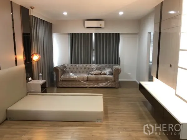 独立式住宅 出租在Prawet, Bangkok - 宽敞卧室起居区，沙发与床台，木地板与空调。