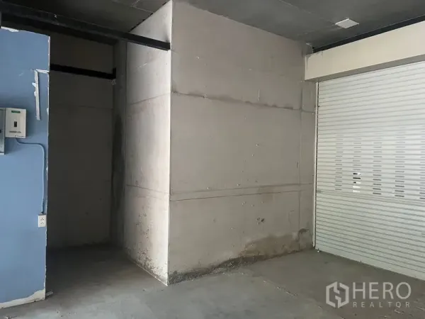 พื้นที่ขายปลีก ให้เช่าในKhlong Toei, Bangkok - มุมภายในร้านแสดงห้องด้านหลังแบบกั้นพื้นที่ มีตู้ไฟและประตูม้วนปิด