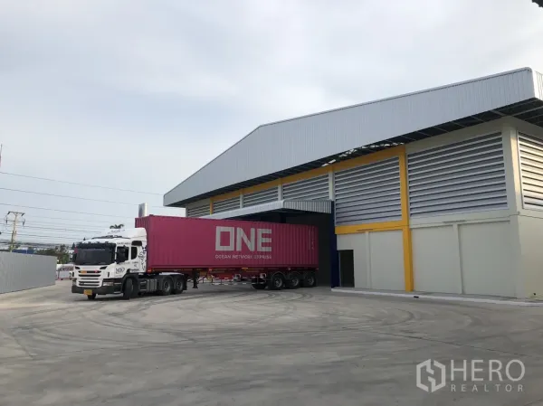 工厂 出租在Mueang Samut Sakhon, Samut Sakhon - 集装箱卡车在带顶装卸位作业，场地宽阔便于大型车辆转弯。