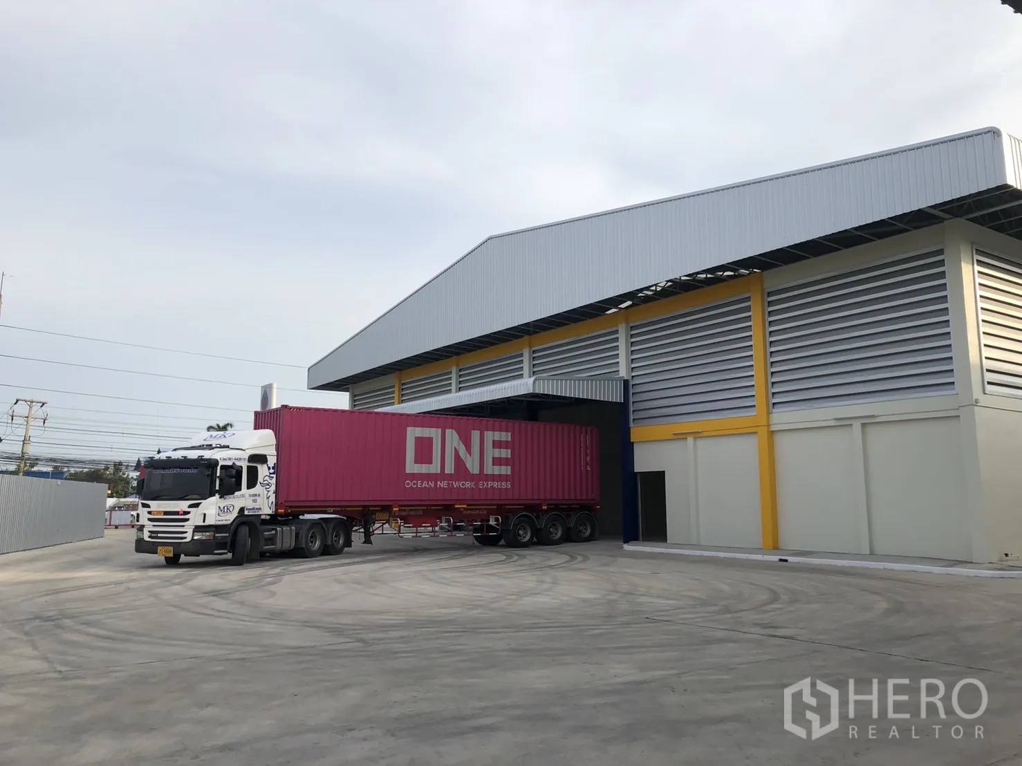 工厂 出租在Mueang Samut Sakhon, Samut Sakhon - 集装箱卡车在带顶装卸位作业，场地宽阔便于大型车辆转弯。