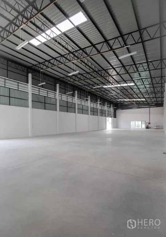 Factory for rent or sale in Bang Len, Nakhon Pathom - Wide production hall showing open floor space and skylight panels along the roof.