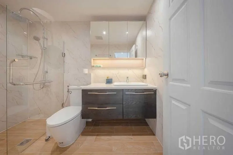 คอนโด ให้เช่า - ห้องน้ำร่วมสมัยมีตู้กระจก อ่างล้างหน้า และโซนอาบน้ำกระจกผนังลายหินอ่อน