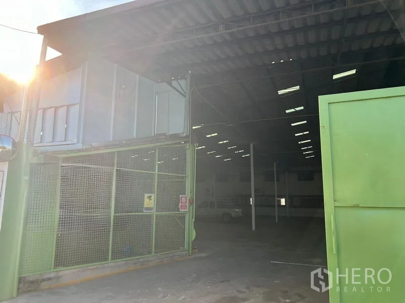 คลังสินค้า ให้เช่าในSamut Prakan - ประตูบานเลื่อนสีเขียวขนาดใหญ่ เปิดสู่ภายในโกดังที่สว่าง