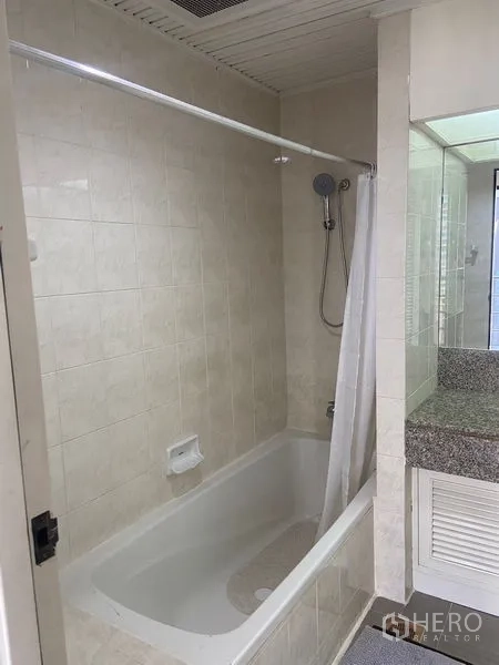 Condominium for rent in Pathum Wan, Bangkok - Bathroom with bathtub, shower and tiled walls.