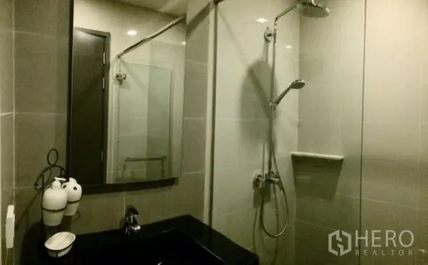 คอนโด ให้เช่าในWatthana, Bangkok - ห้องน้ำสมัยใหม่พร้อมห้องอาบน้ำกระจก ฝักบัวเรนชาวเวอร์ และอ่างล้างหน้าท็อปสีดำ