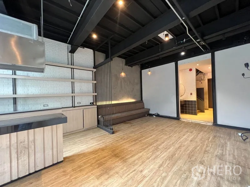 店屋 出租 - 零售区带层架与沙发长椅，可通往后场。