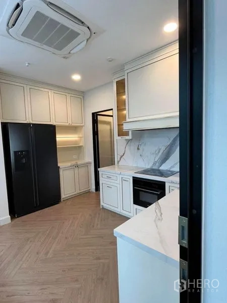 Detached House for rent in Saphan Sung, Bangkok - Closed modern kitchen with marble backsplash, built-in oven and large refrigerator.
