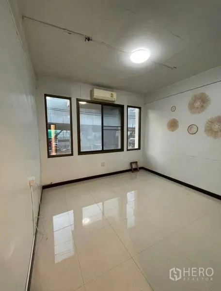 Shophouse for rent in Chatuchak, Bangkok - Bright room with windows, tiled floor and a wall-mounted air conditioner.