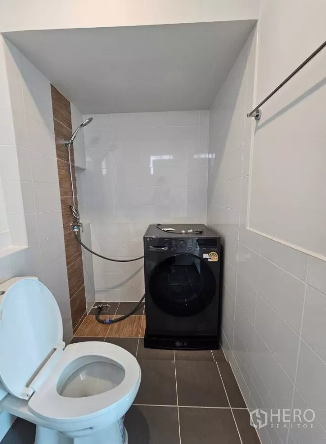 Detached House for rent in Bang Phli, Samut Prakan - Bathroom with washing machine area, toilet and handheld shower.