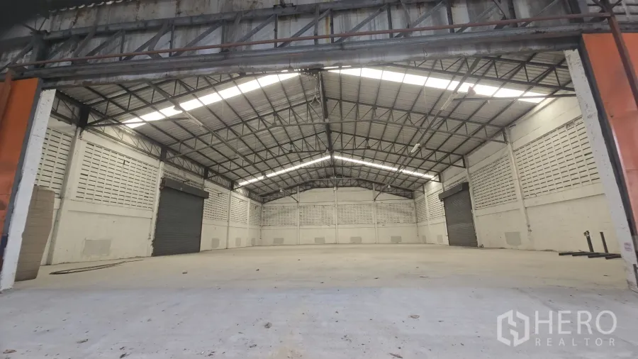 Warehouse for rent in Khlong Sam Wa, Bangkok - Spacious warehouse interior with high gable steel roof, skylights and twin roller shutters.