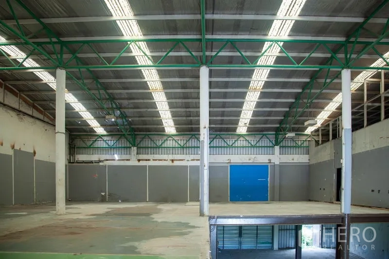 货栈 出租在Prawet, Bangkok - 高位屋顶下的抬高平台，天窗采光与结构立柱清晰可见。