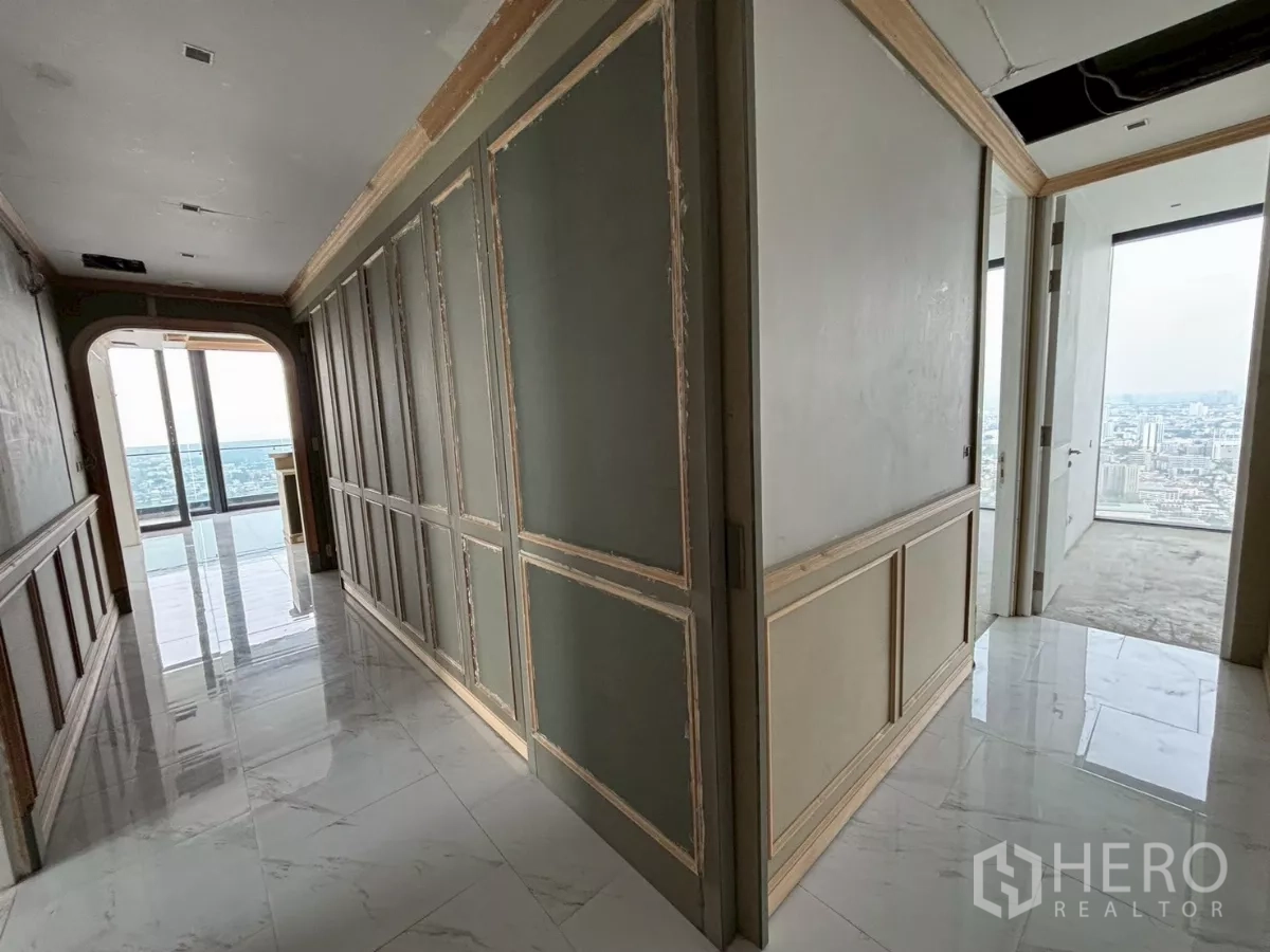 Condominium for sale in Bang Kho Laem, Bangkok - Elegant corridor with paneled walls and marble floors leading toward a balcony.