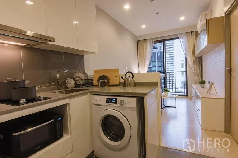 公寓 出售在Watthana, Bangkok - 全配厨房，含炉灶、水槽、洗衣机与微波炉，通向客厅与阳台。