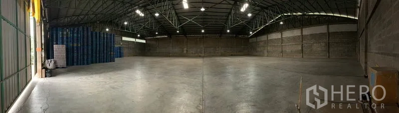 货栈 出租在Mueang Pathum Thani, Pathum Thani - 仓库全景，开阔无柱布局、顶部照明清晰，可见侧面装卸通道。