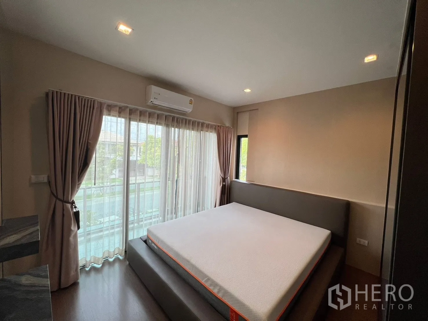 Detached House for rent in Bang Phli, Samut Prakan - Light-filled bedroom with balcony access, sheer curtains, and a corner window.