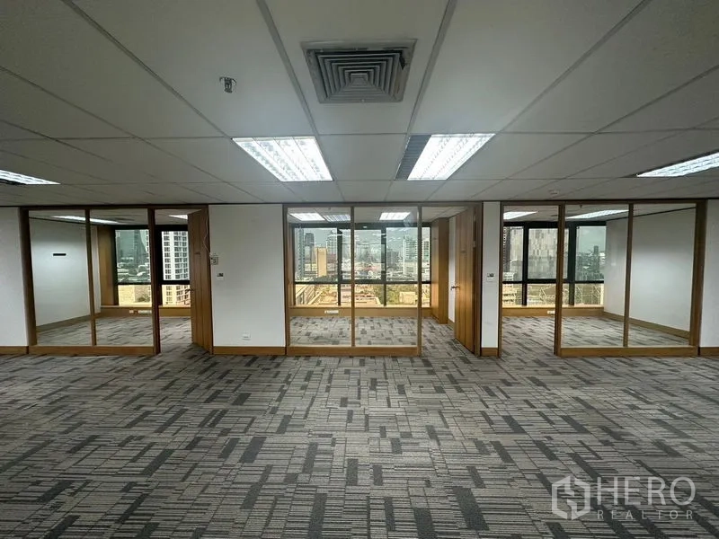 Office Space for rent in Khlong Toei, Bangkok - Row of glass-fronted private offices with city views beyond.