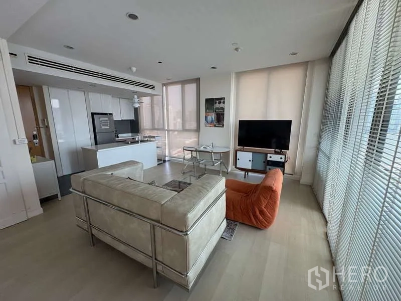 Condominium for rent - Spacious living zone with kitchen island, TV and full-height glazing.