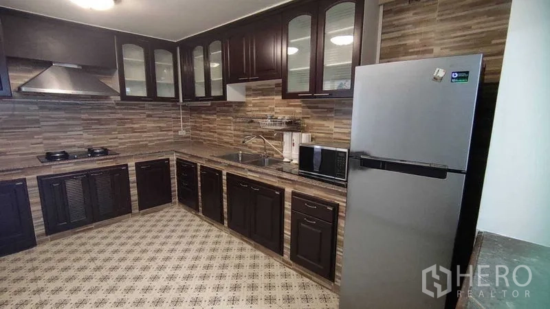 Home Office for rent in Watthana, Bangkok - U-shaped kitchen with tiled backsplash, range hood and stainless refrigerator.