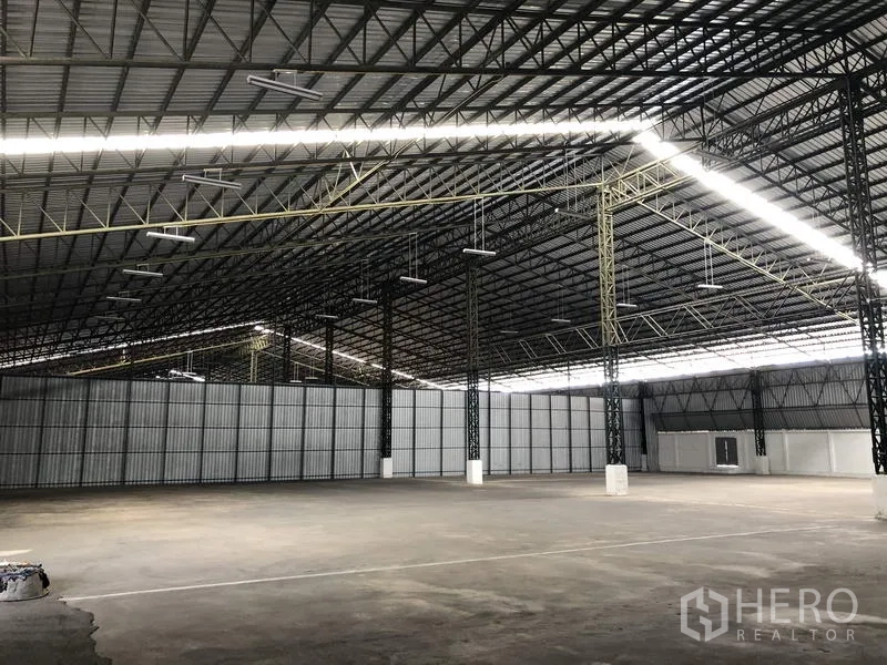 货栈 出租在Mueang Pathum Thani, Pathum Thani - 工业仓库空间，金属板墙体与条形照明，超大面积适合仓储与物流作业。