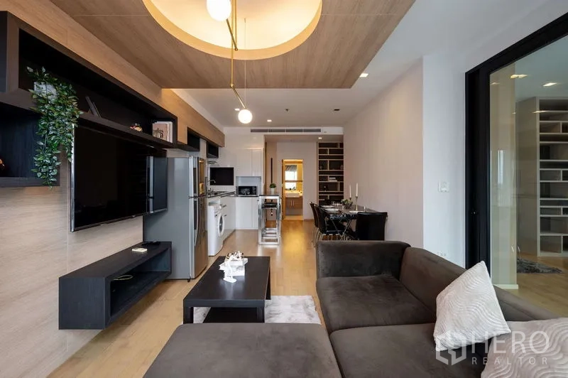 คอนโด ขายในWatthana, Bangkok - ผนังทีวีพร้อมชั้นลอย ข้างครัวแบบเปิด ไอส์แลนด์ และโต๊ะทานอาหาร ใต้ฝ้าเพดานดีไซน์