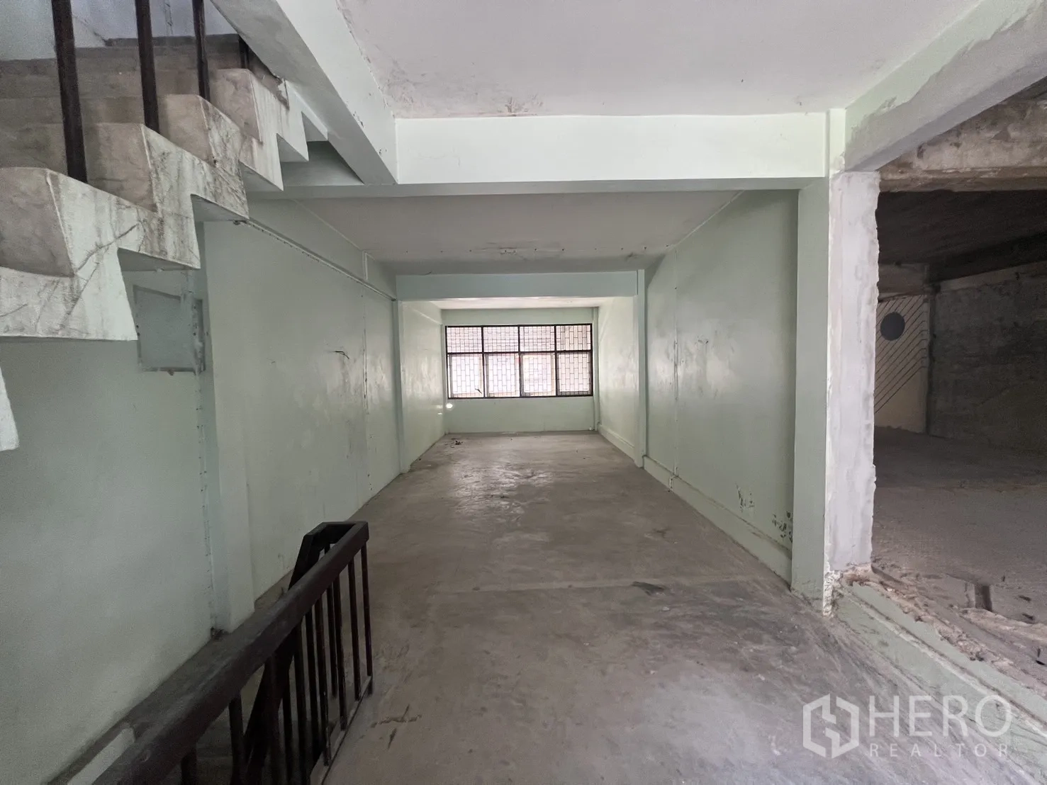 店屋 for rent in Bang Rak, Bangkok - 长形房间，尽头有窗，侧边为楼梯。