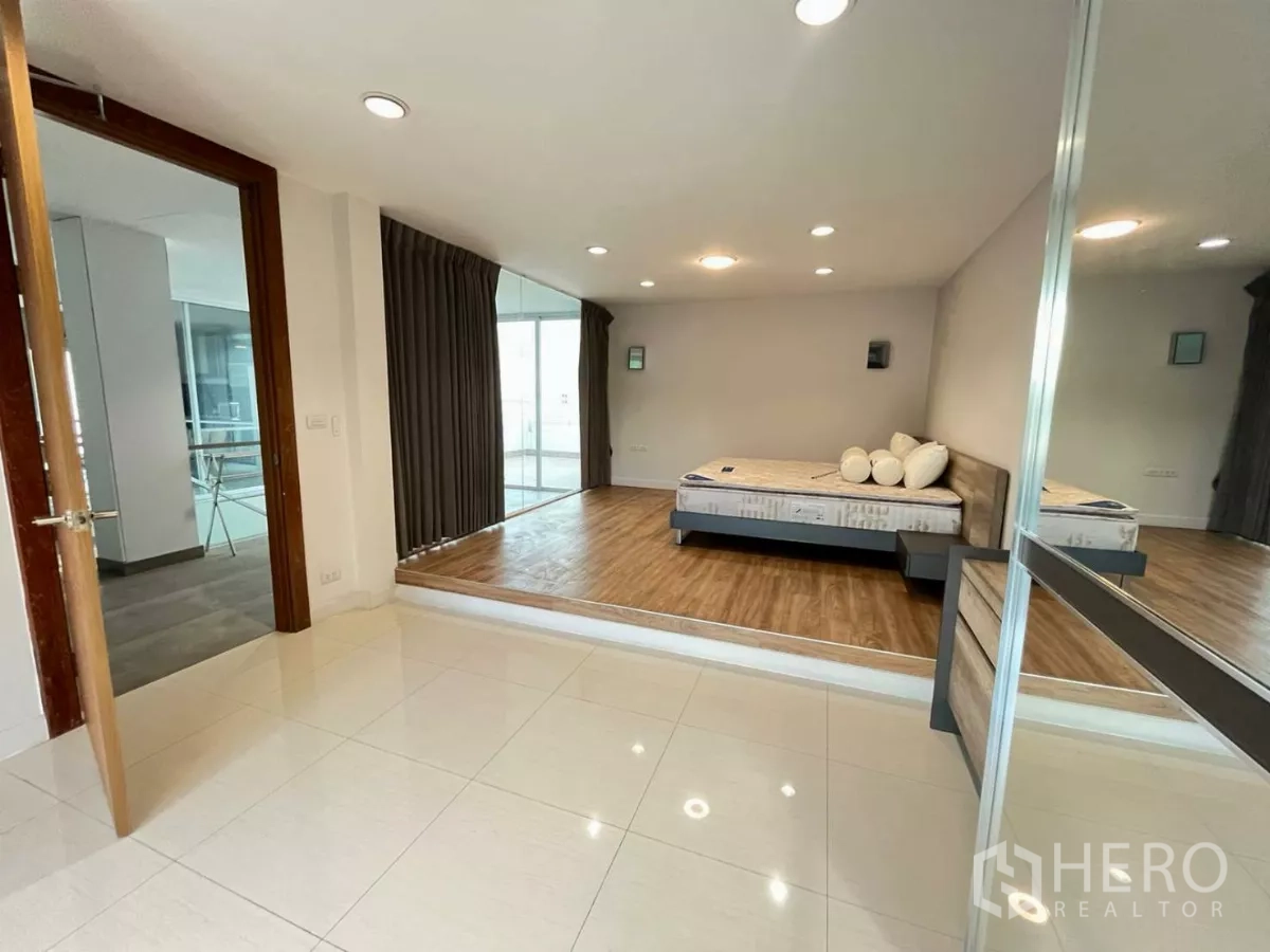 Home Office for rent in Khlong Toei, Bangkok - Bedroom with raised platform bed, mirrored wardrobe and access to terrace.