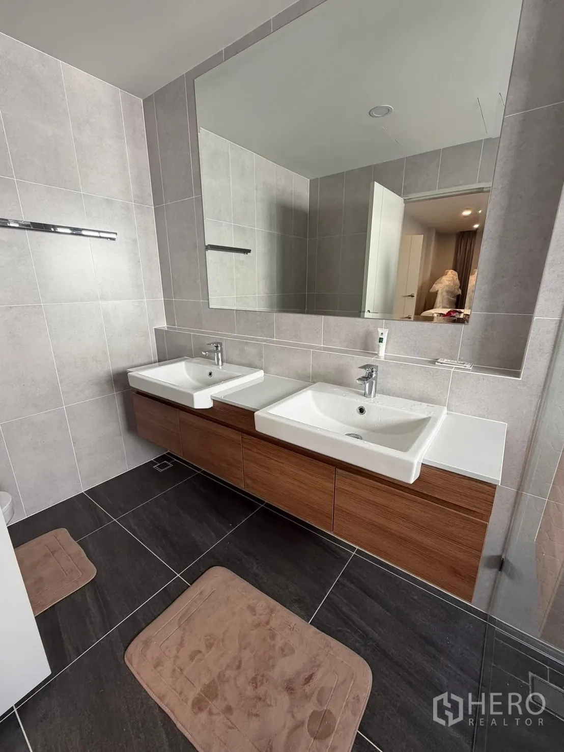 Detached House for rent in Bang Phli, Samut Prakan - Modern bathroom with double sinks on a wood vanity and a large mirror.
