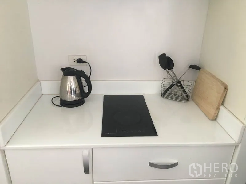 คอนโด ให้เช่าในWatthana, Bangkok - เคาน์เตอร์ครัวมินิมอล พร้อมกาต้มน้ำ เตาไฟฟ้า ที่ใส่อุปกรณ์ และเขียง