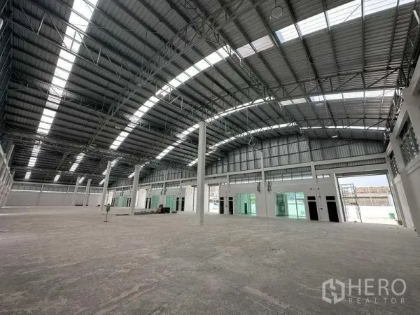 Factory for rent in Khlong Luang, Pathum Thani - Open-plan warehouse interior showing clear-span structure and multiple loading doors.