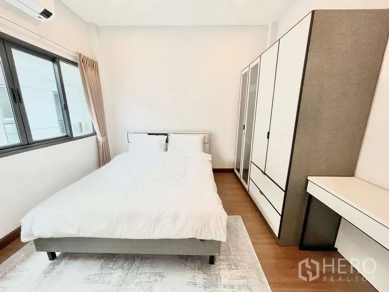 Detached House for rent in Bang Phli, Samut Prakan - Cozy guest bedroom with bed, wardrobe set and study desk by the window.