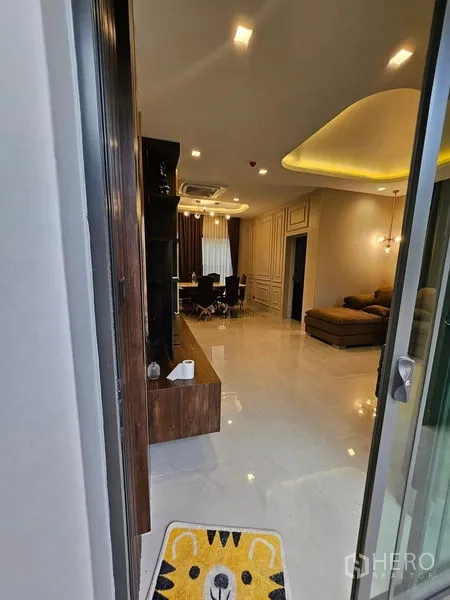 Detached House for sale in Mueang Pathum Thani, Pathum Thani - Entry view to the living–dining area with glossy tile floors and recessed lights.