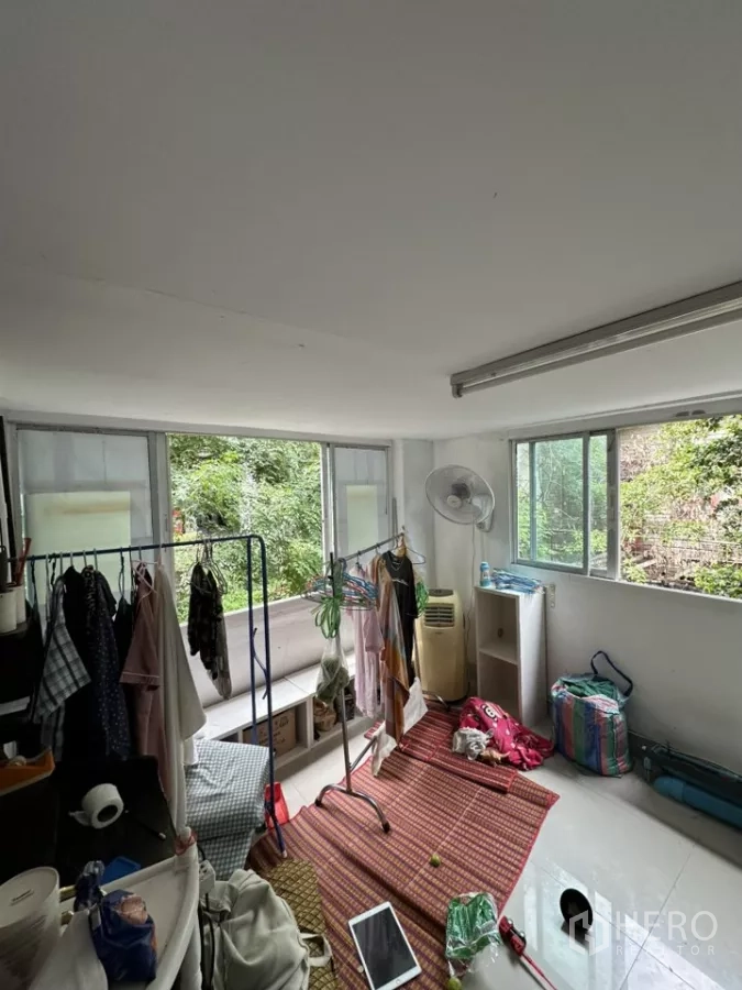 พื้นที่ขายปลีก ให้เช่า - ห้องอเนกประสงค์สว่าง มีหน้าต่างบานเลื่อน ราวตากผ้า และวิวต้นไม้ด้านนอก