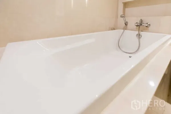 Condominium for rent - Close-up of a deep soaking bathtub with handheld shower.