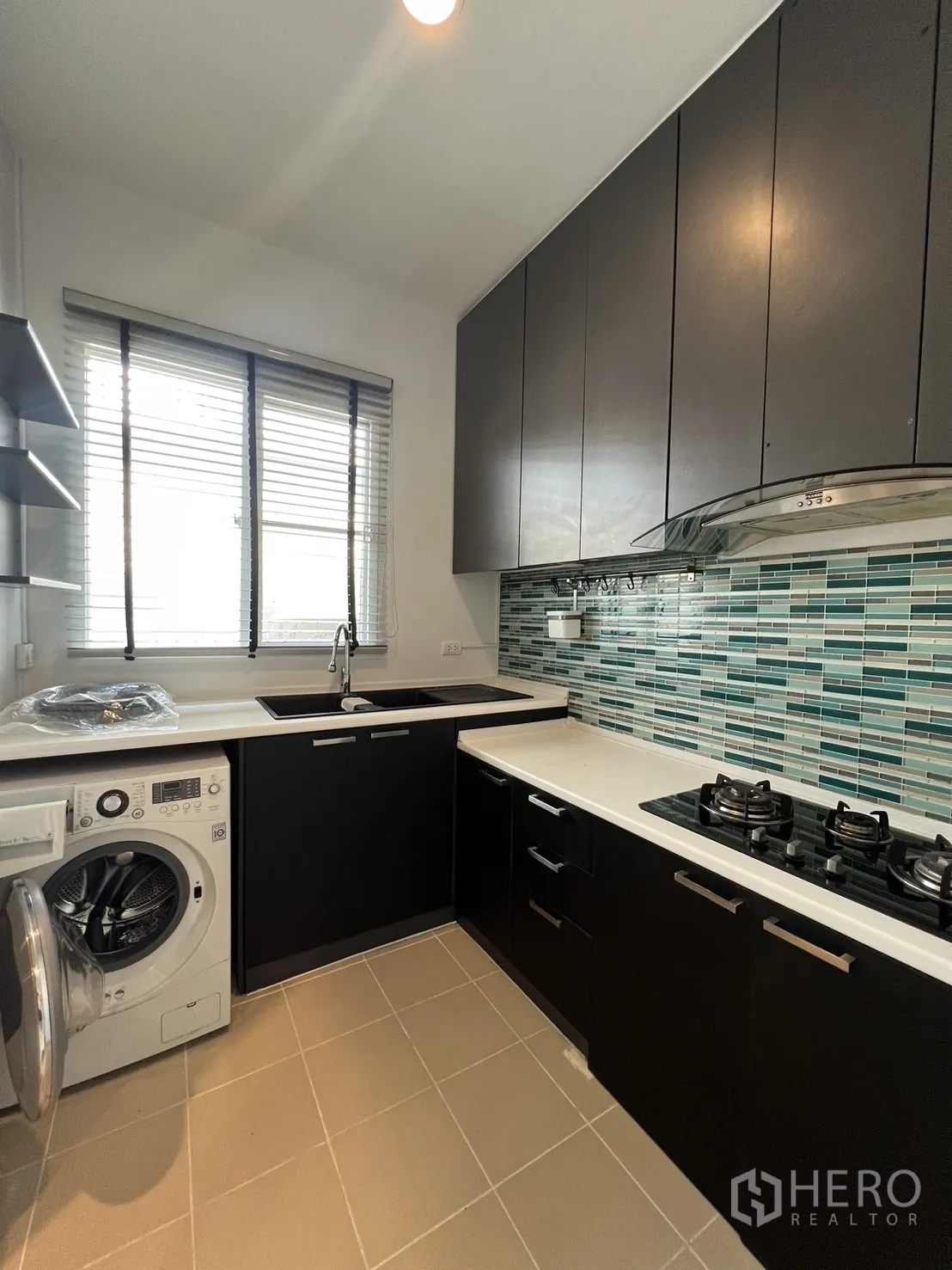 Townhouse for rent in Wang Thonglang, Bangkok - Bright kitchen with window, mosaic backsplash and washer.