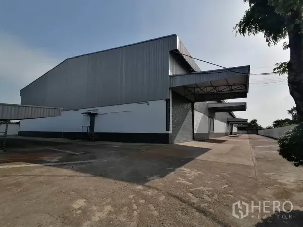 货栈 出租在Lat Krabang, Bangkok - 曼谷叻甲挽区现代金属外墙仓库外观，设多处有顶装卸月台及宽阔混凝土场地。