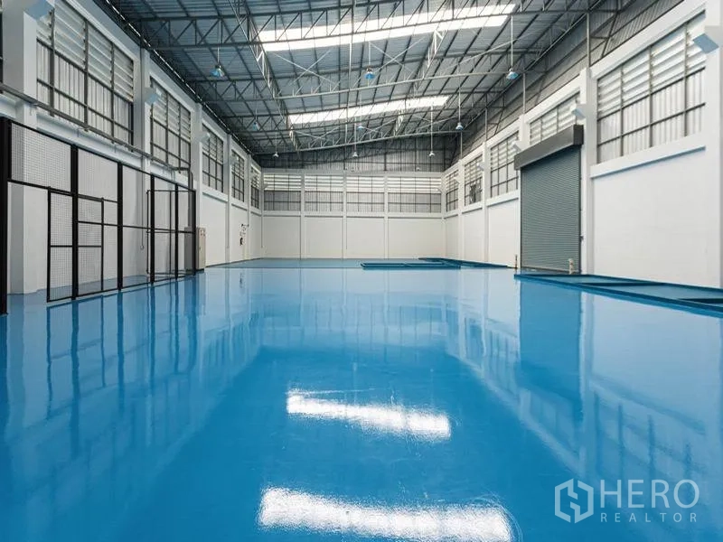 工厂 出租在Bang Bo, Samut Prakan - 厂房内部挑高空间，亮蓝色环氧地坪，天窗采光与大型卷闸门通行