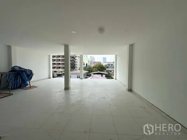Home Office for sale in Bang Phli, Samut Prakan - Spacious open-plan floor with white walls, tiled flooring and a wide front opening overlooking the neighborhood in a new home office.