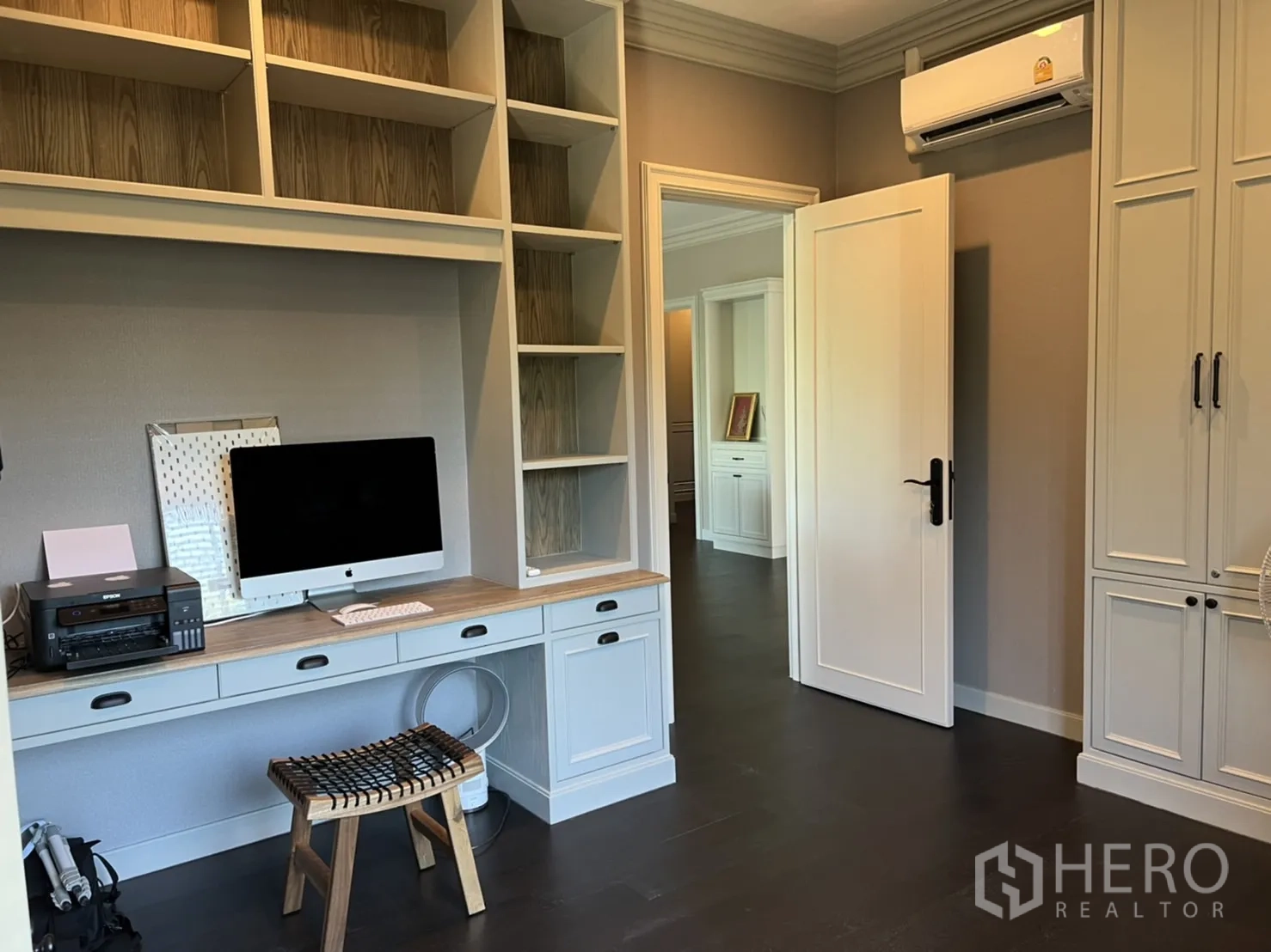 Detached House for rent or sale in Bang Kapi, Bangkok - Functional home office with built-in desk and shelving, air conditioning and doorway to the upper hallway.