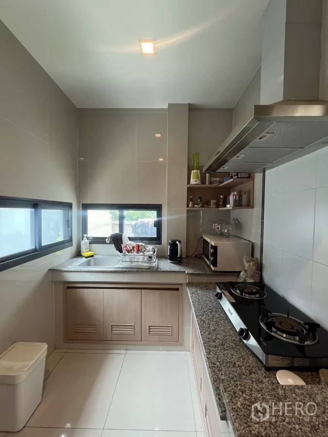Detached House for rent in Bang Kapi, Bangkok - Built-in kitchen with granite countertops, gas hob, and corner shelves.