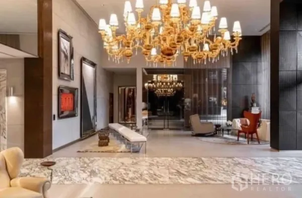 公寓 出租在Watthana, Bangkok - 通罗区公寓豪华大堂，金色吊灯、云石地面与休息区。