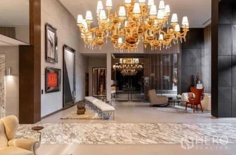 公寓 出租在Watthana, Bangkok - 通罗区公寓豪华大堂，金色吊灯、云石地面与休息区。