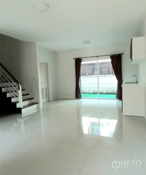 ทาวน์เฮาส์ ขายในMueang Pathum Thani, Pathum Thani - มุมมองห้องนั่งเล่นเชื่อมครัวและบันได พร้อมประตูกระจกบานใหญ่รับแสงธรรมชาติ