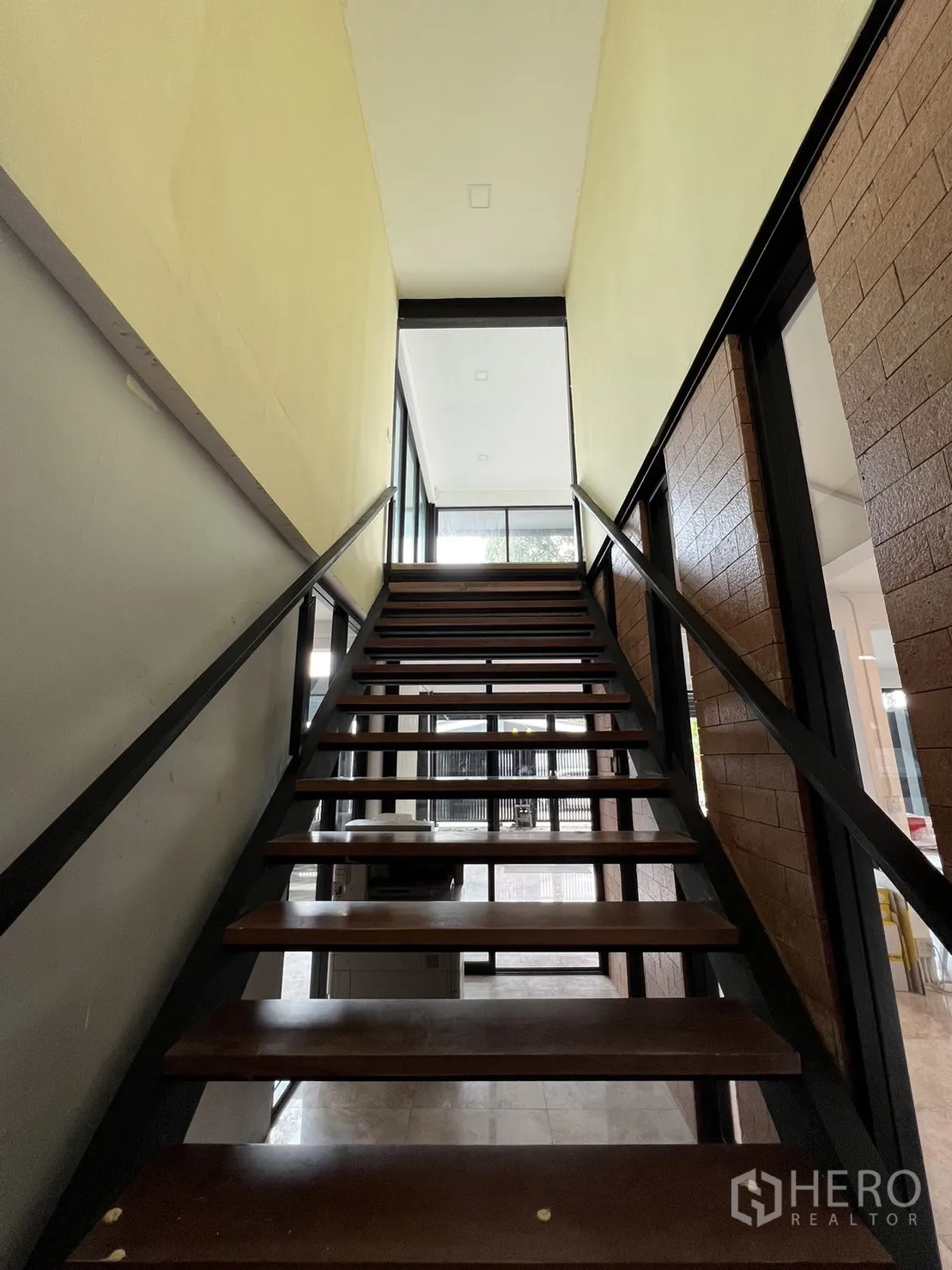 บ้าน ให้เช่าหรือขายในPhra Khanong, Bangkok - บันไดไม้พร้อมราวเหล็กสีดำขึ้นสู่ชั้นบน