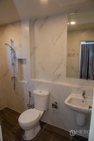 Detached House for rent in Bang Phli, Samut Prakan - Modern bathroom with marble tiles, shower, toilet and wall mirror.