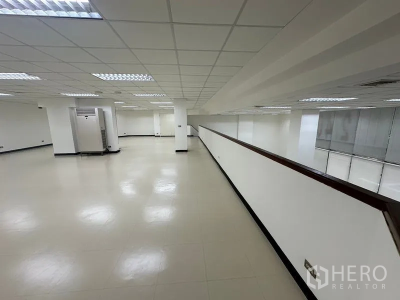 展厅 出租 - 宽阔夹层区域带立柱与照明，适合展示或办公室。