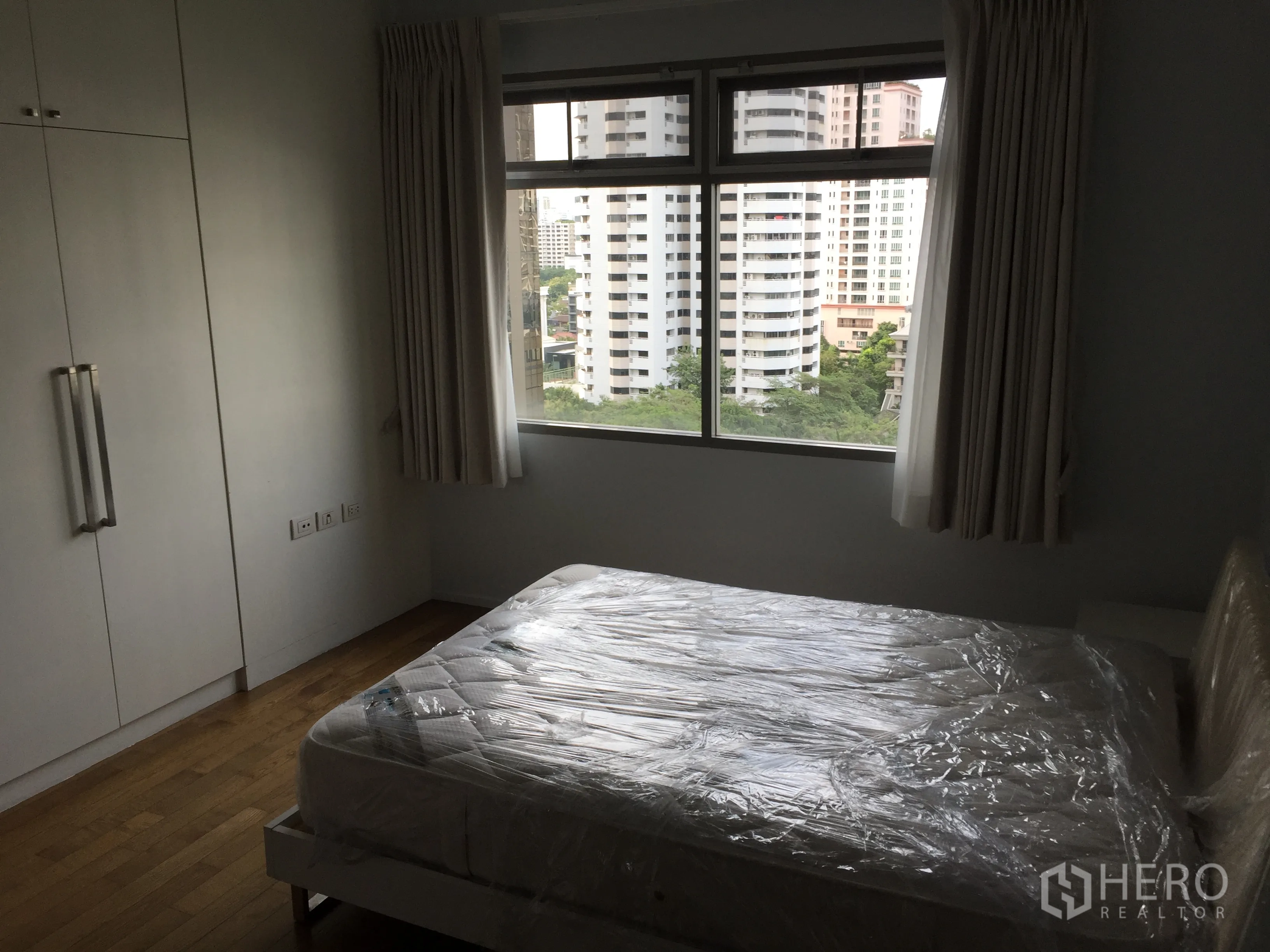 คอนโด ให้เช่าในWatthana, Bangkok - ห้องนอนมีตู้เสื้อผ้าบิลต์อิน หน้าต่างบานใหญ่ มุมมองเมืองตึกสูงและพื้นที่สีเขียว