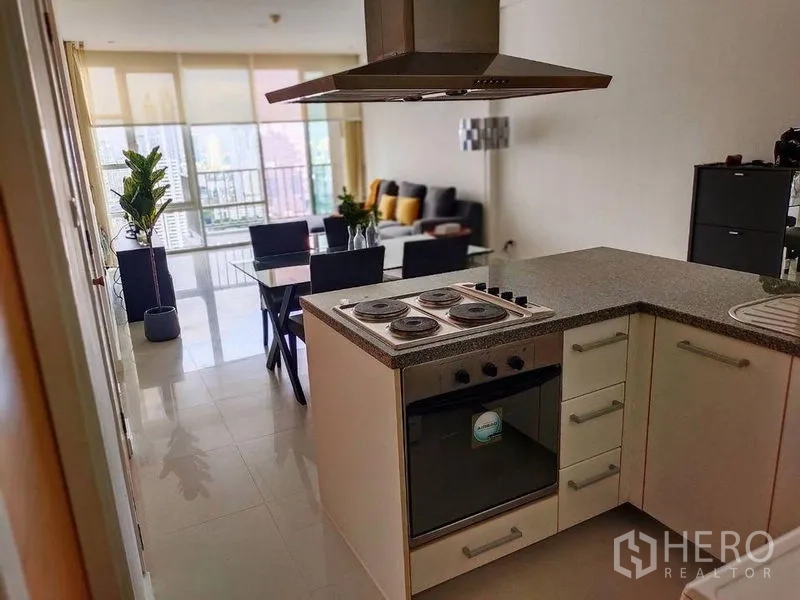 คอนโด ให้เช่าในWatthana, Bangkok - ครัวแบบเปิดพร้อมเตาไฟฟ้าและเตาอบ เชื่อมต่อโซนรับประทานอาหารและห้องนั่งเล่นวิวเมือง
