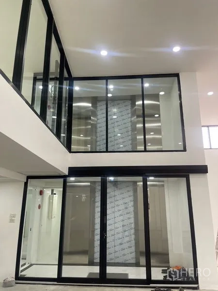 Home Office for rent or sale in Wang Thonglang, Bangkok - Double-height glass meeting or showroom area with sliding doors.