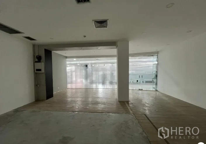 พื้นที่ขายปลีก ให้เช่า - มองลึกจากด้านในไปยังประตูกระจก หน้า-พื้นผสมไม้และคอนกรีต เหมาะปรับฟิตเอาต์